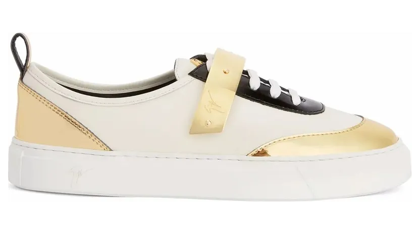 Giuseppe Zanotti Sneaker basse en cuir blanc avec tissu synthétique doré et inserts en cuir verni noir, arborant un détail signature » en métal doré sur la languette. une sangle en métal assorti ornée du logo et une semelle en caoutchouc blanc complètent ce modèle. (RS20062001)