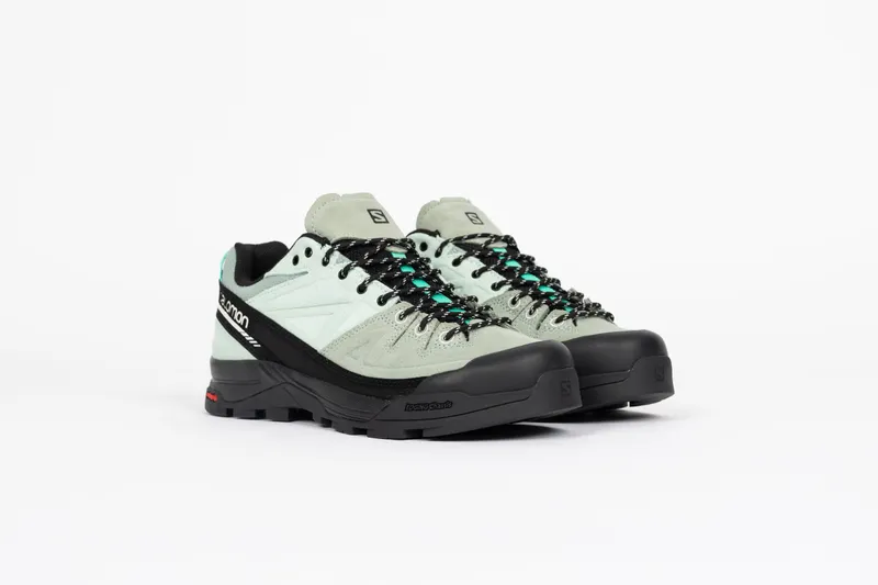 Salomon Der <b><i>Salomon X-ALP Leather</i></b> wirft ein Licht auf Salomons Bergsteigergeschichte und verbindet schützende Details mit funktionalen Merkmalen. Er ist aus hochwertigem Wildleder und Canvas gefertigt und verfügt über eine gummierte Zehenpartie und ein seitliches, genähtes Powerband für zusätzlichen Schutz. Er basiert auf dem <i>3D Edging Chassis™</i> und sorgt für seitliche Stabilität und Vorfußbeweglichkeit, wodurch er sich ideal für abwechslungsreiche Landschaften eignet. “Mint/Black” (L47596100)